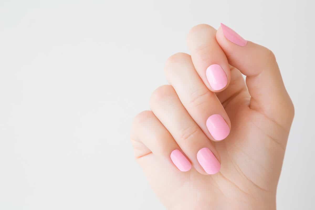 Красивая ухоженная женская рука с розовыми ногтями