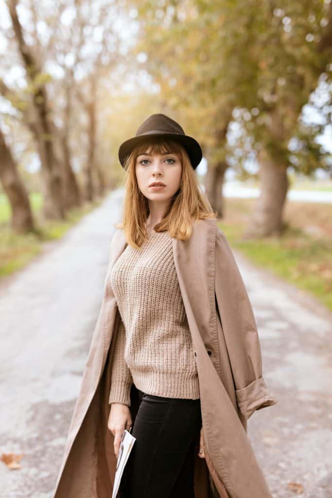 Beautiful woman wearing a light brown trench coat and sweater