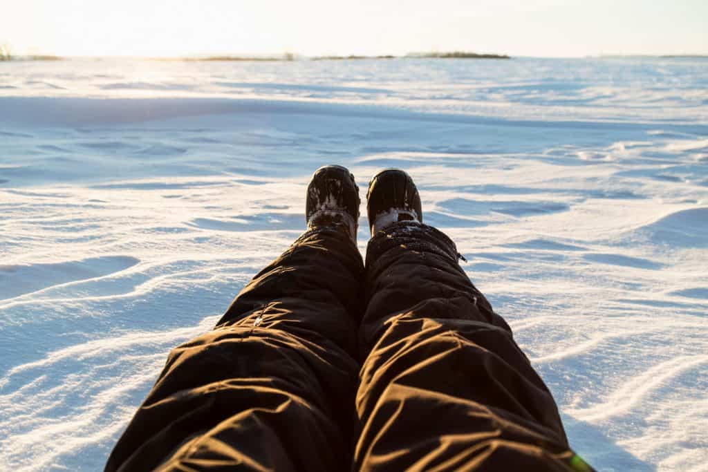 Personal perspective of a person's legs and feet in a cold snowy winter landscape.