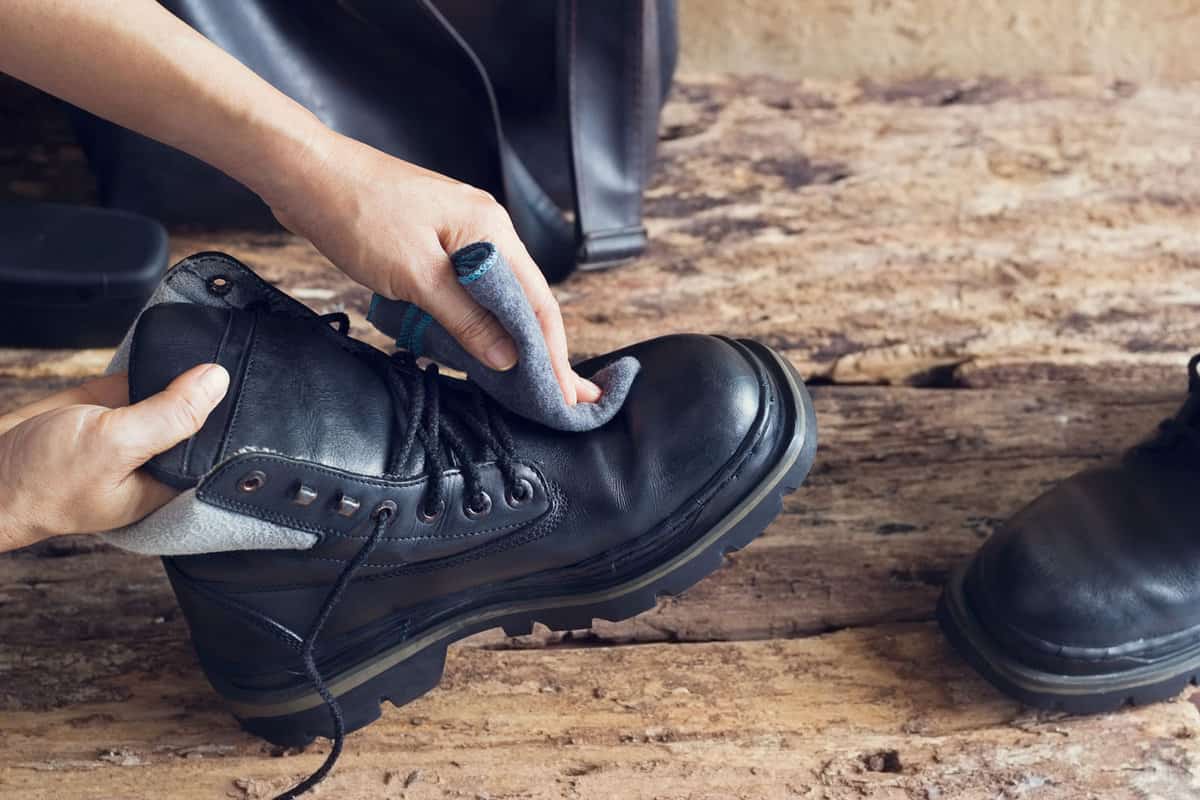 Woman wiping the leather shoes with new shoe shine