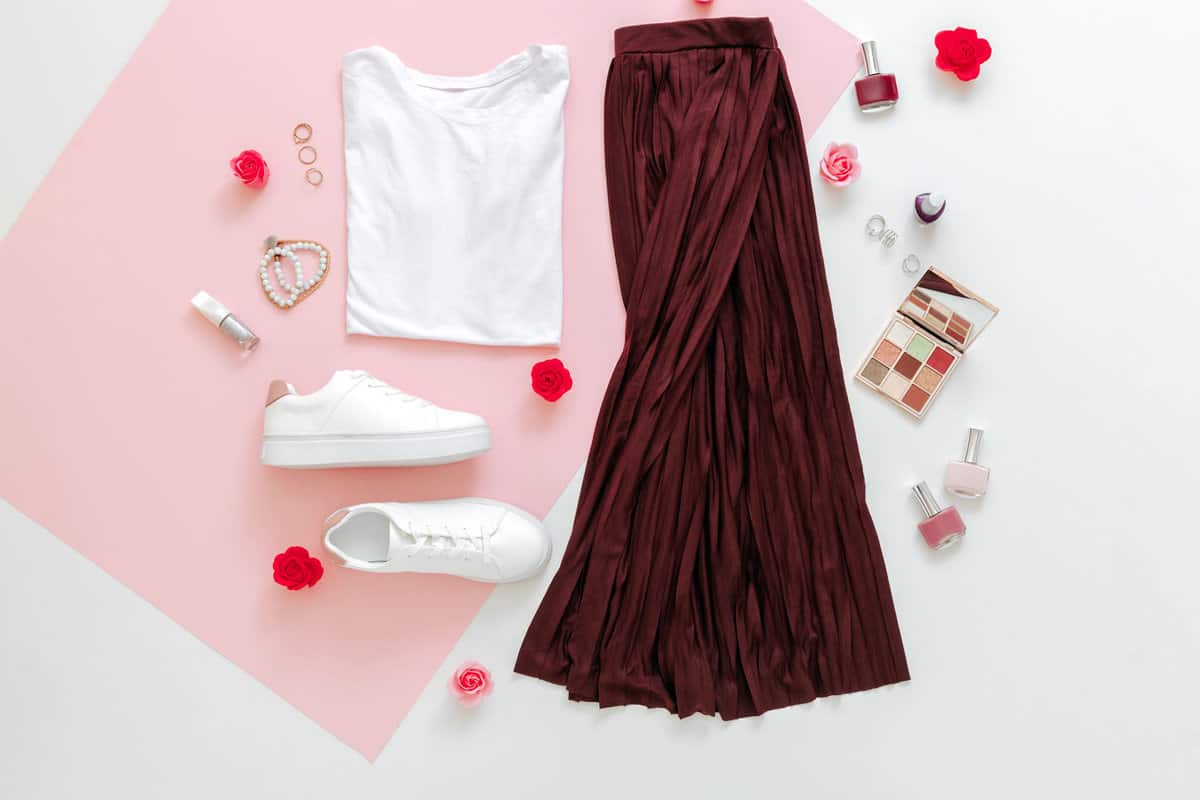 White shirt, white shoes and a burgundy skirt on the side with nail polishes and make up
