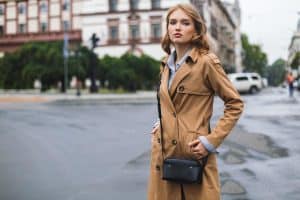 Young attractive woman in trench coat with little black cross bag, How Long Should A Trench Coat Be And How Should It Fit (For Men And Women)