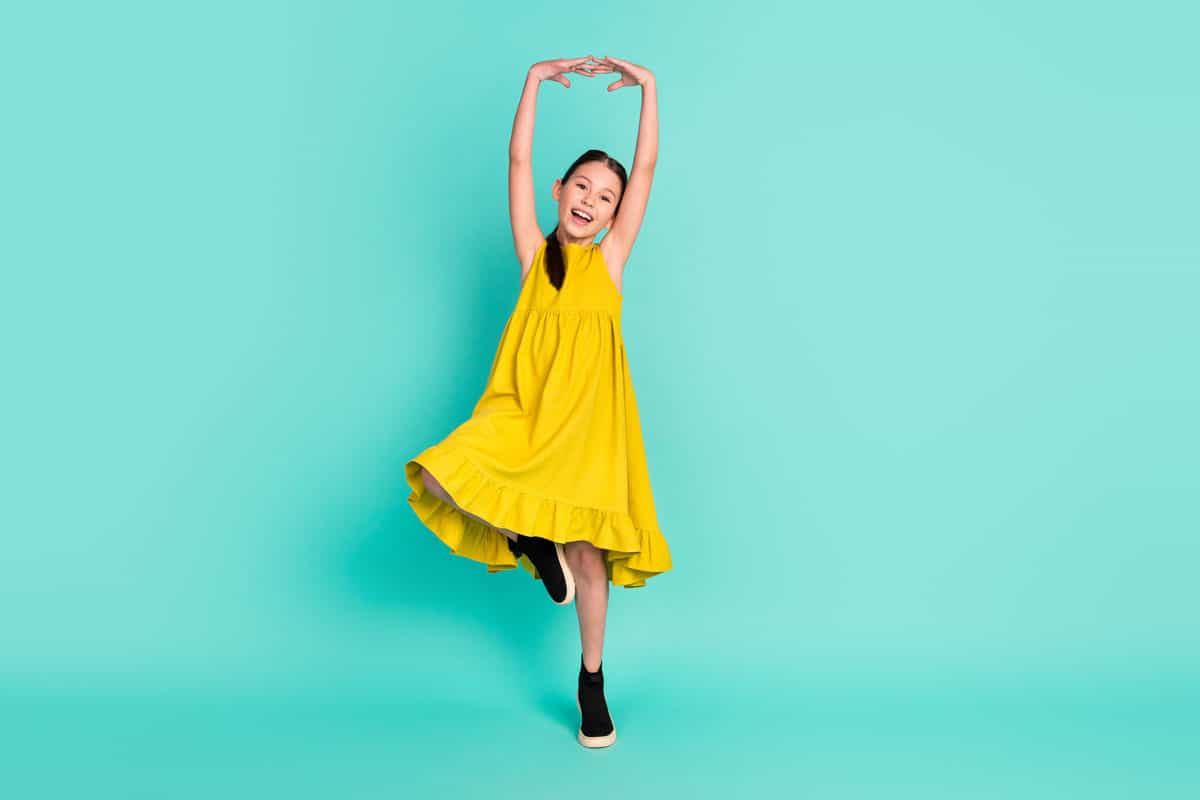 Young lady in a dancing pose with yellow dress