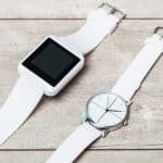 An image of a smart watch lying next to a normal analog watch.