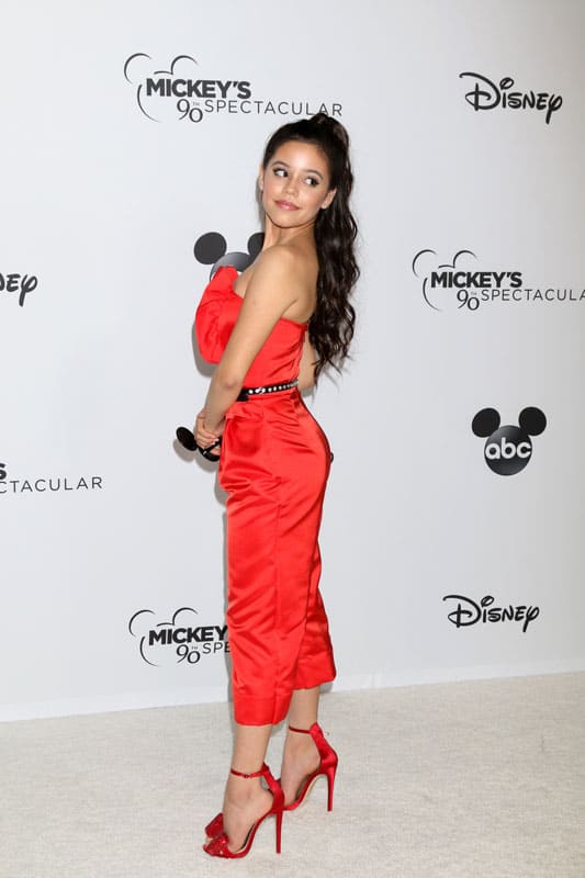 Jenna Ortega wearing a dazzling bright red dress with matching red heels at the Mickey's 90th Spectacular Taping