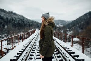 Winter journey. Girl in winter clothes on railway bridge in winter day, Do Parkas Have Linings And Hoods (And How Warm Can They Keep You)