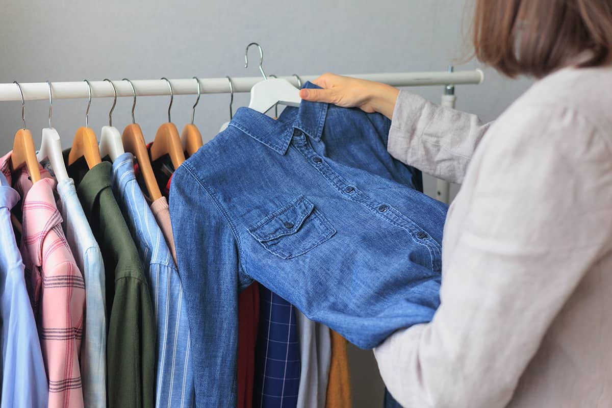 Woman chooses clothes in wardrobe