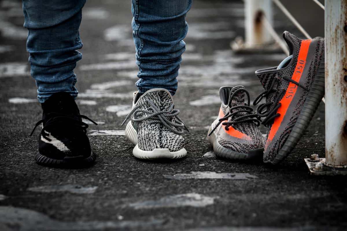 A person wearing a Yeezy 350 V2 "Oreo", a Yeezy 350 "Turtle Dove" with a pair of Yeezy 350 V2 "Beluga" on the side, [The Scoop] Viral Sensation Discovers Low-Cost Yeezy Dupe at Walmart