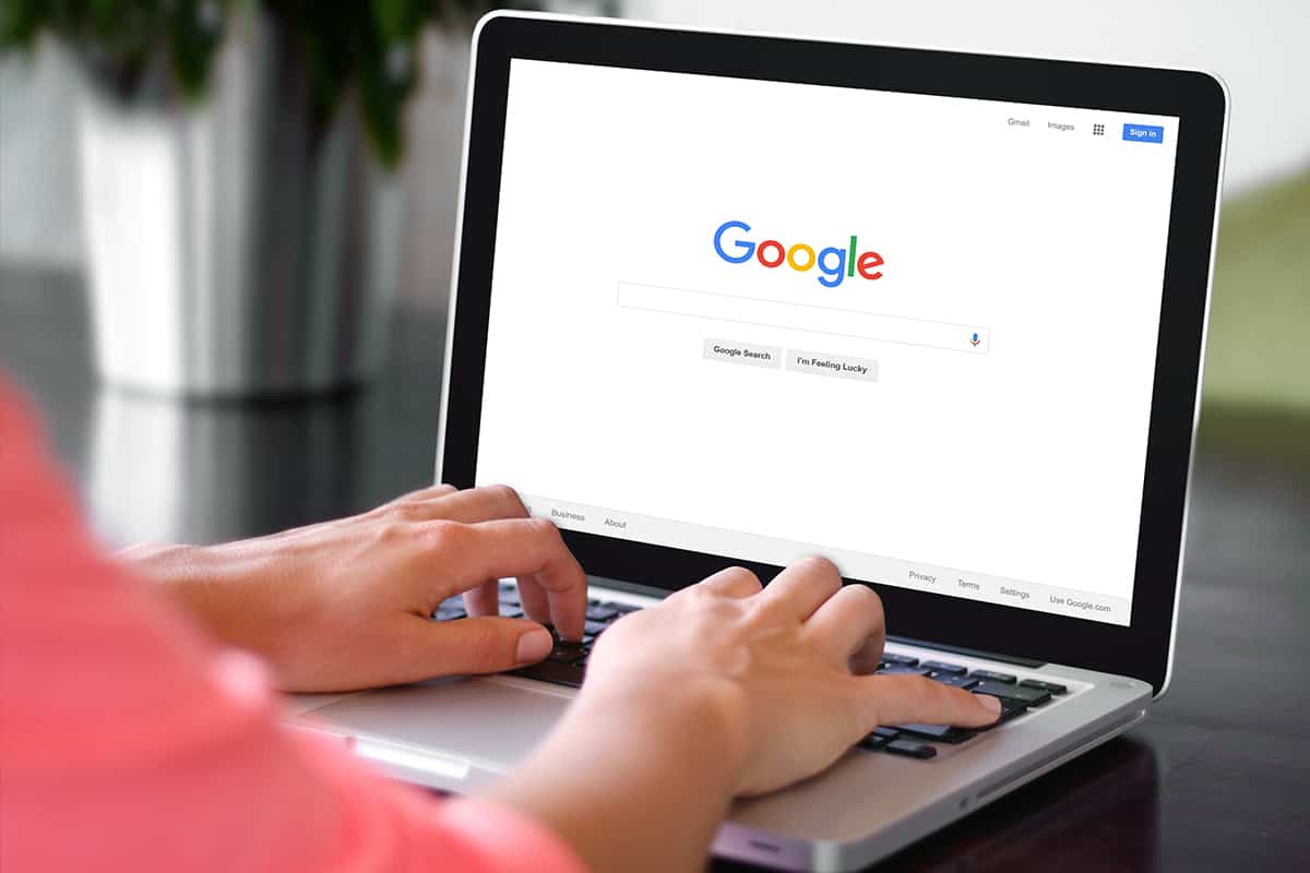 A woman is typing on Google search engine from a laptop