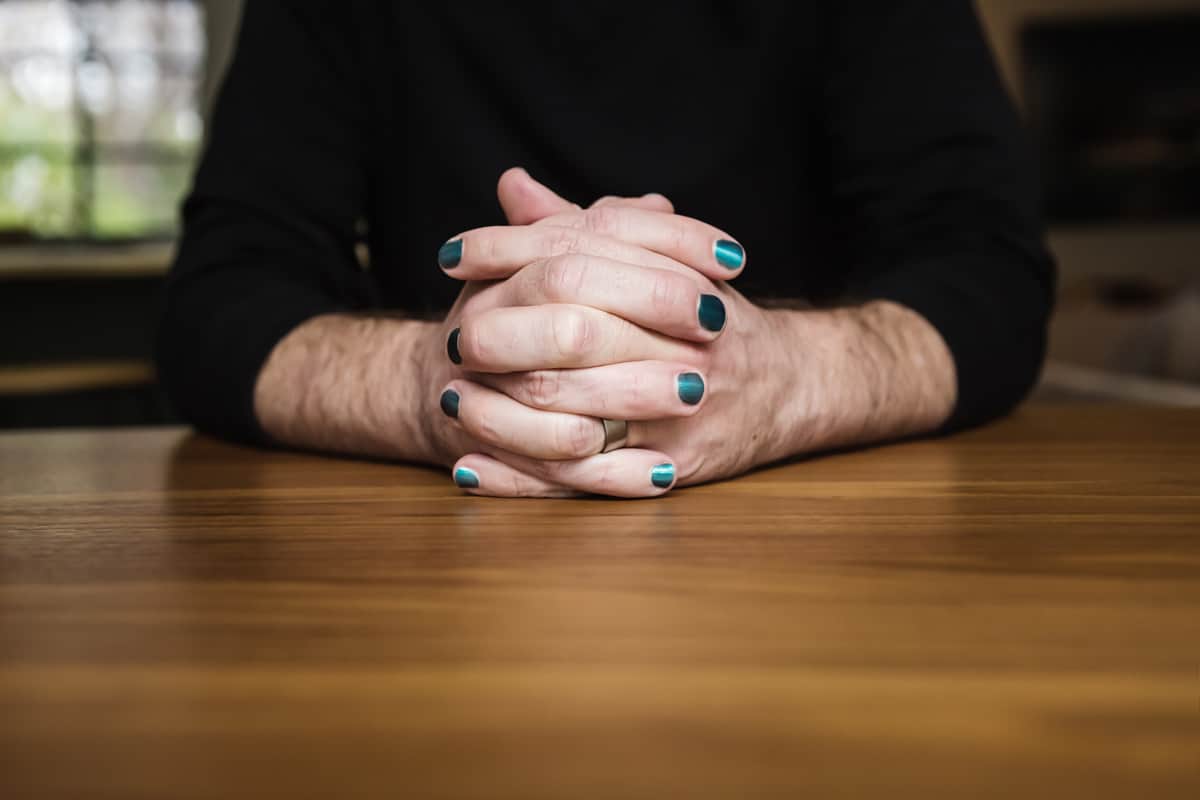 Close up of male hands clasped with nail polish