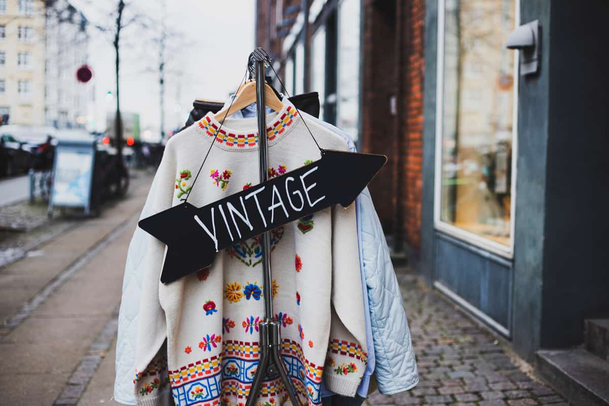 Vintage sign with a background of different vintage clothing on a street