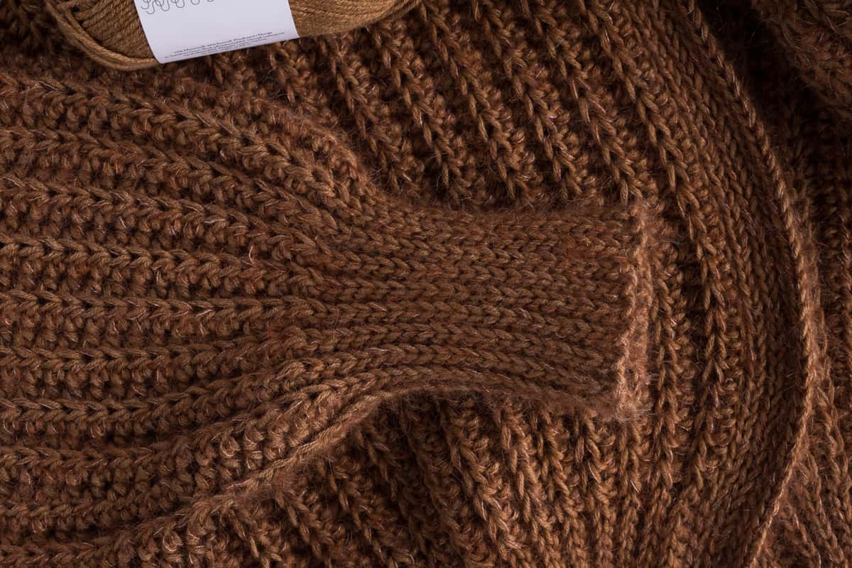 Warm caramel crochet jacket sleeve folded over itself and half a yarn at the t