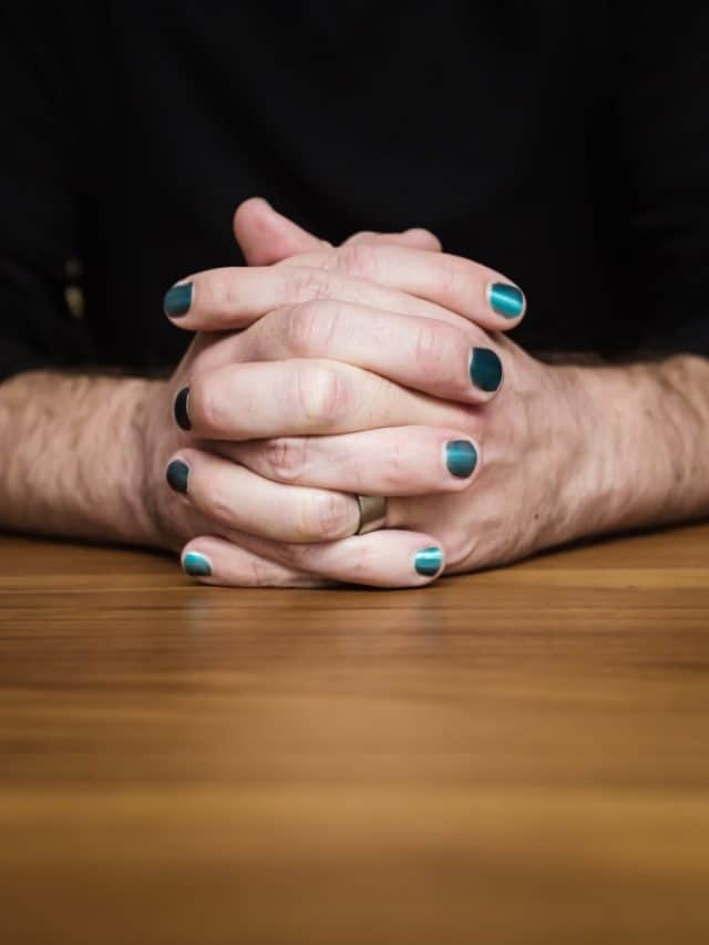 Close up of male hands clasped with nail polish
