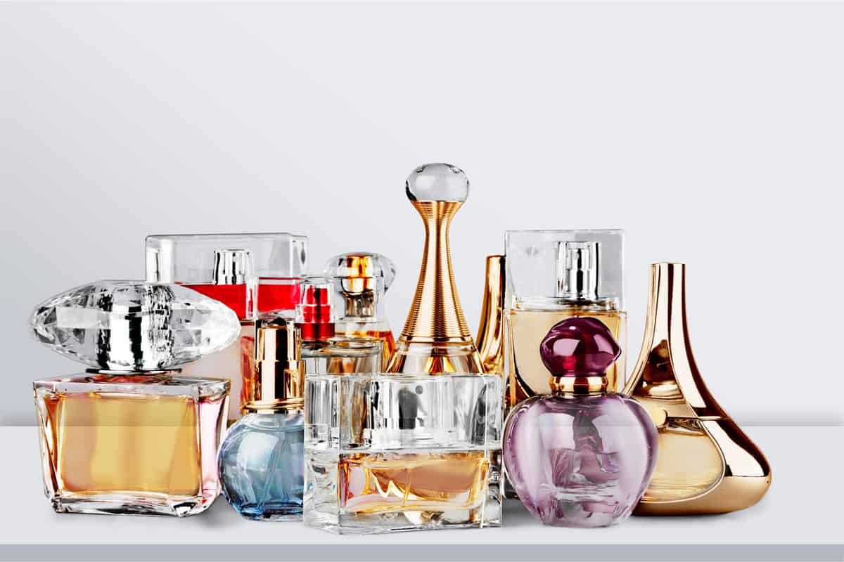 Aromatic Perfume bottles on white wooden desk at wooden