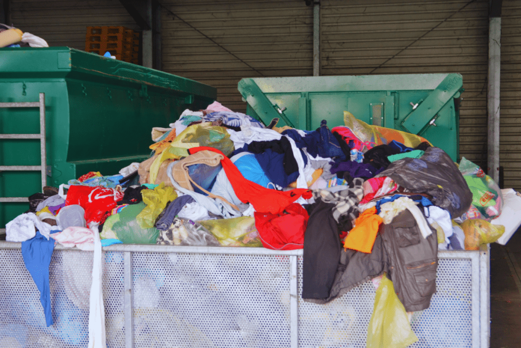 Used clothes at recycling utility. A glimpse of the environmental impact of fast fashion