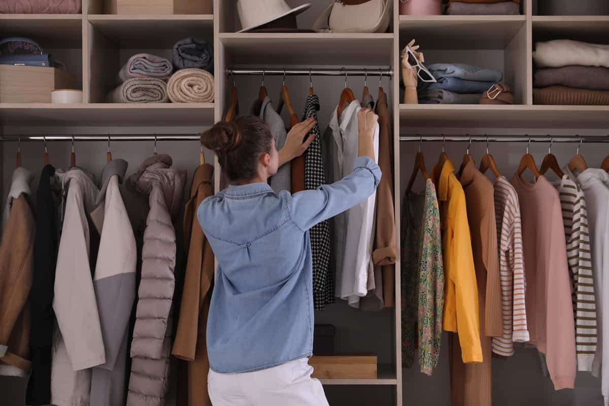Woman choosing jackets in her large cabinetWoman choosing jackets in her large cabinet