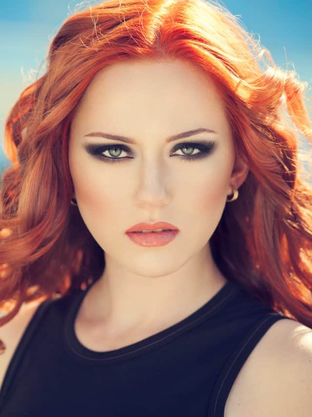 Summer portrait of beautiful woman with red hair and smoky eyes makeup