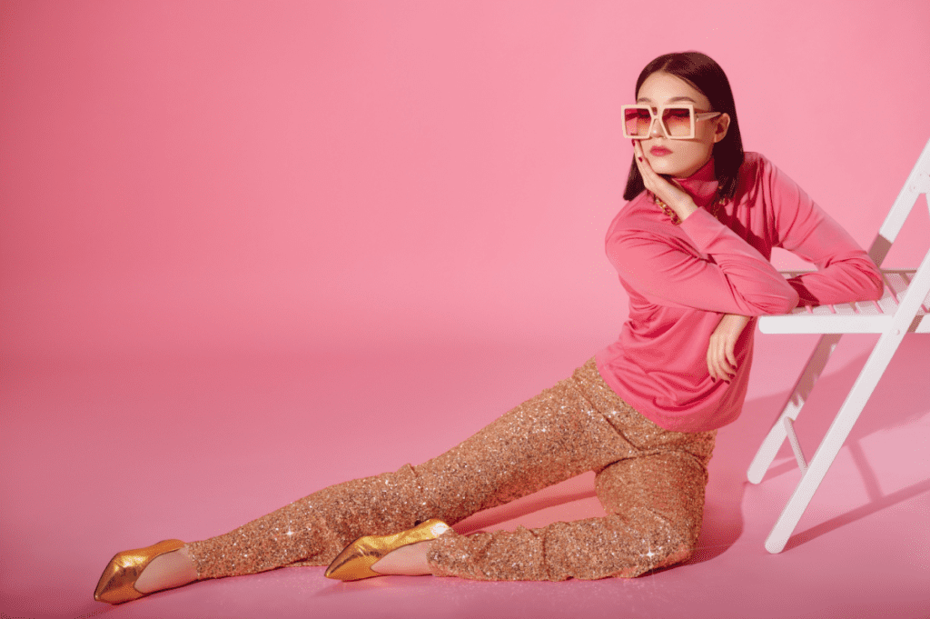 Image of an attractive woman wearing glittery sequin gold pants and a pink top.