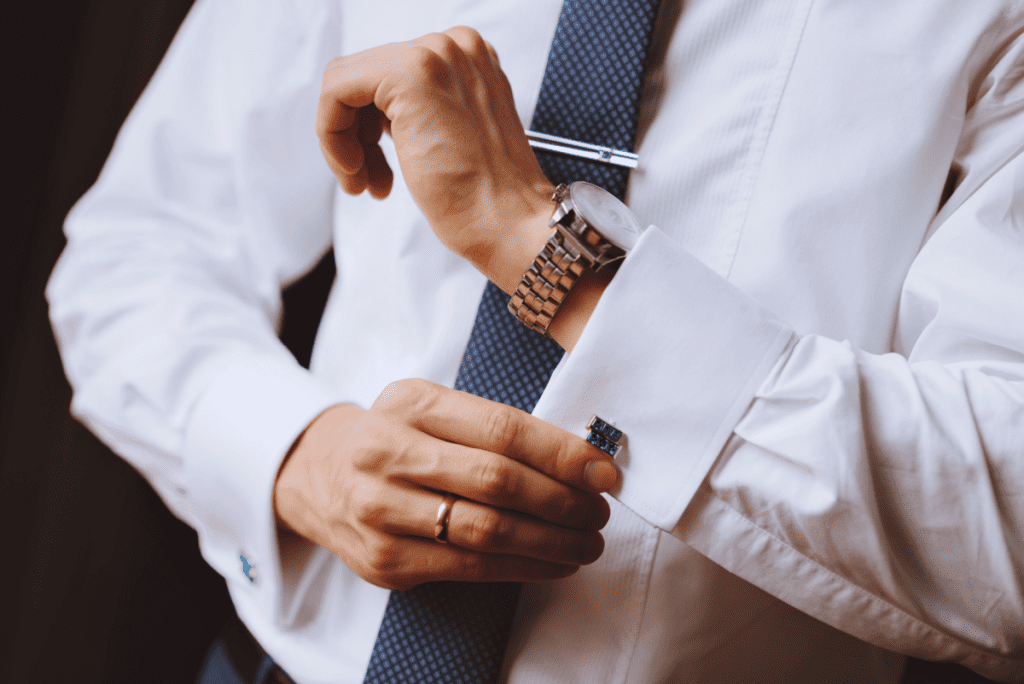 Image of a man dressed in a nice shirt and tie, wearing cufflinks and a traditional analog watch