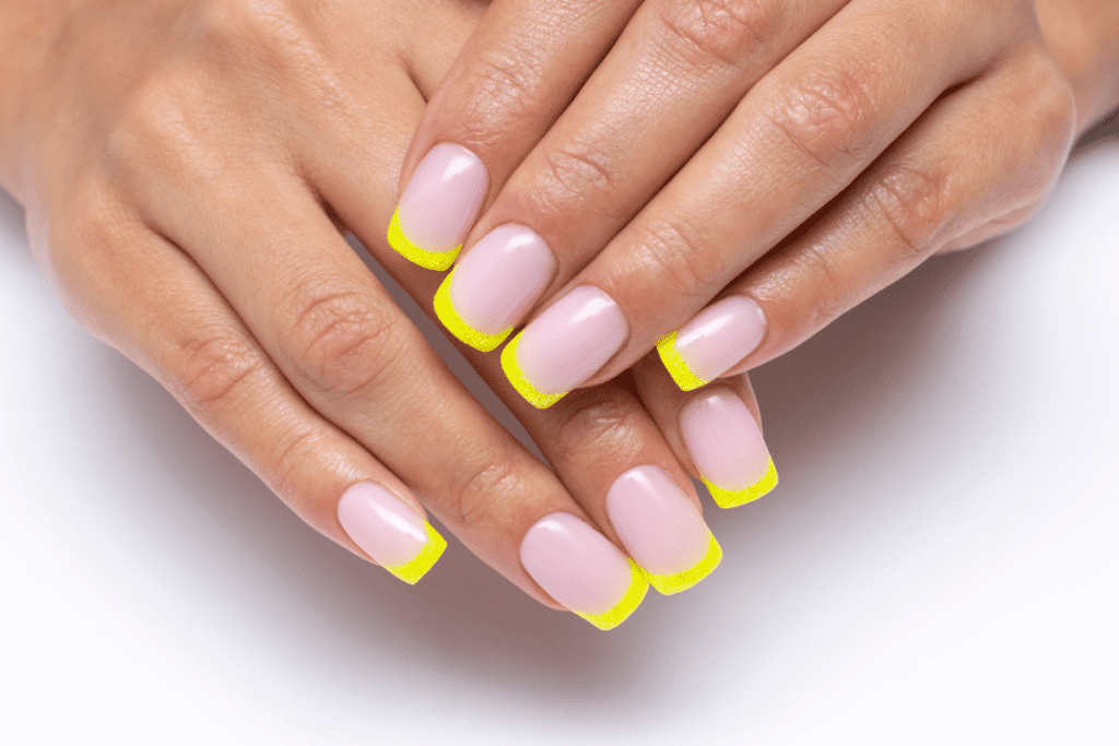 Image of a french manicure with a nude pink nail bed and a neon yellow tip