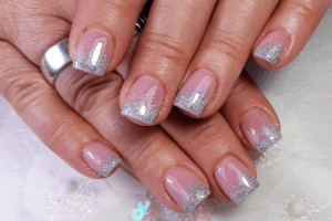 French manicure featuring pink nail beds and silver glitter tips