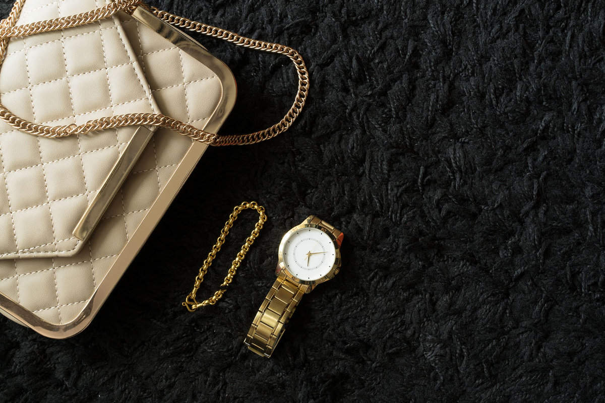 A handbag, watch, and golden bracelet