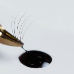 Applying lash glue onto fake eyelashes, Why Is My Lash Glue Not Sticking? [Common Reasons and Solutions] - 1600x900