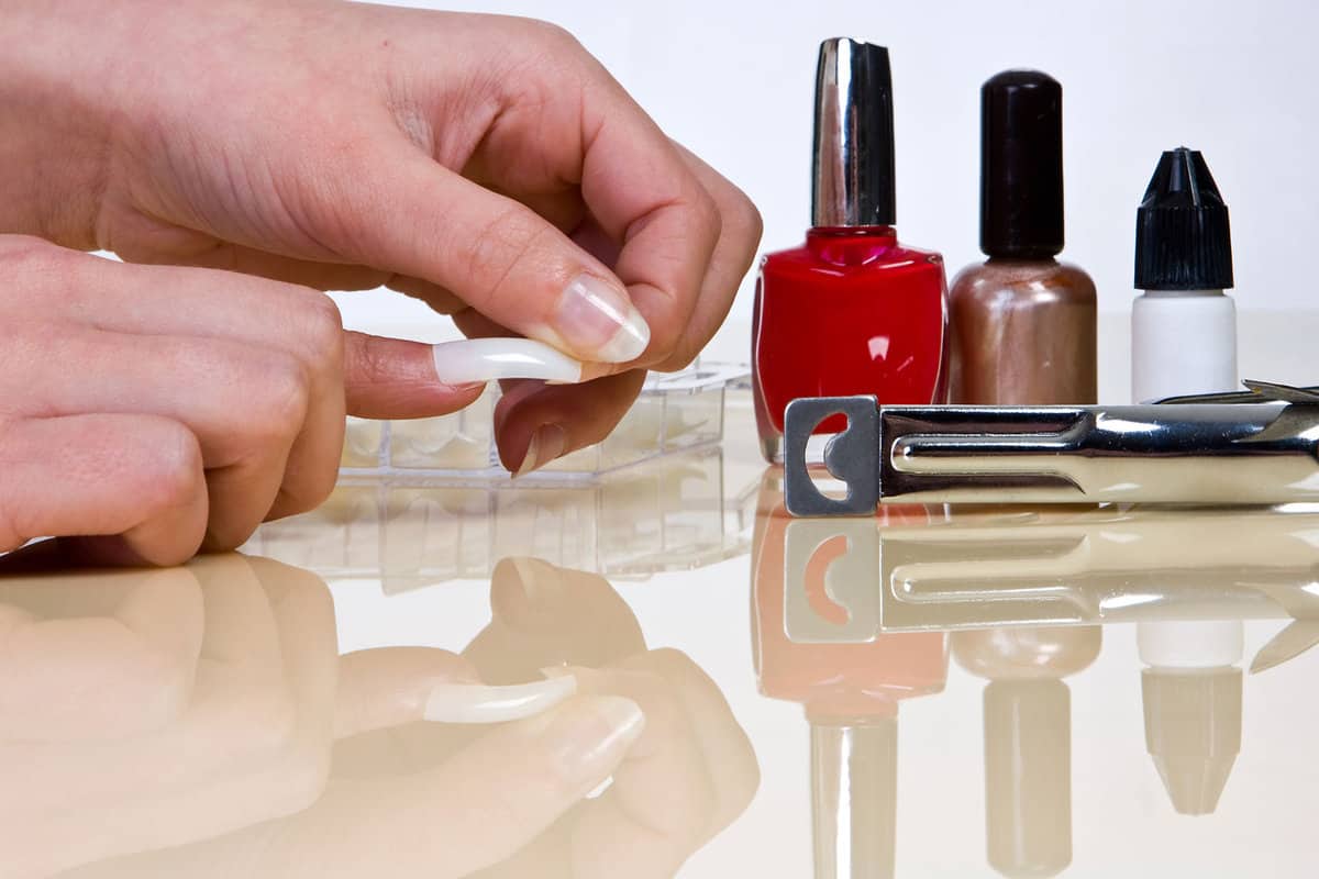 Woman putting on acrylic nails