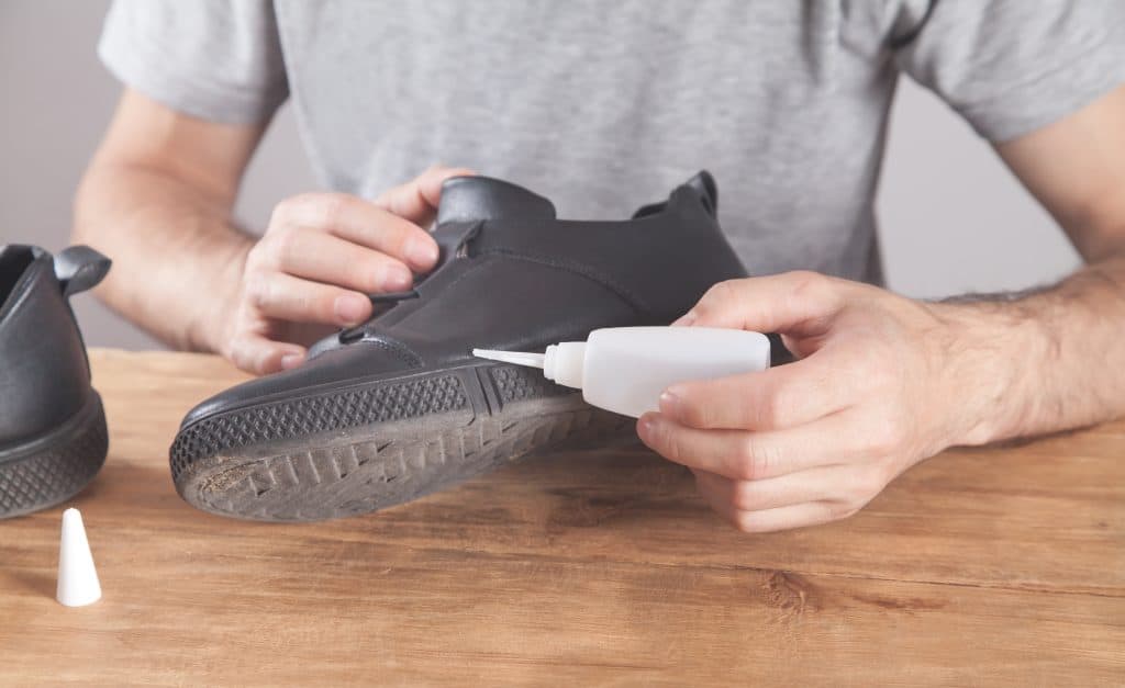 Man repairing shoe using gorilla glue, Can Gorilla Glue Fix Shoes? - 1600x900