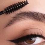 Woman curling her brows, Do You Need Glue For Brow Lamination? - 1600x900