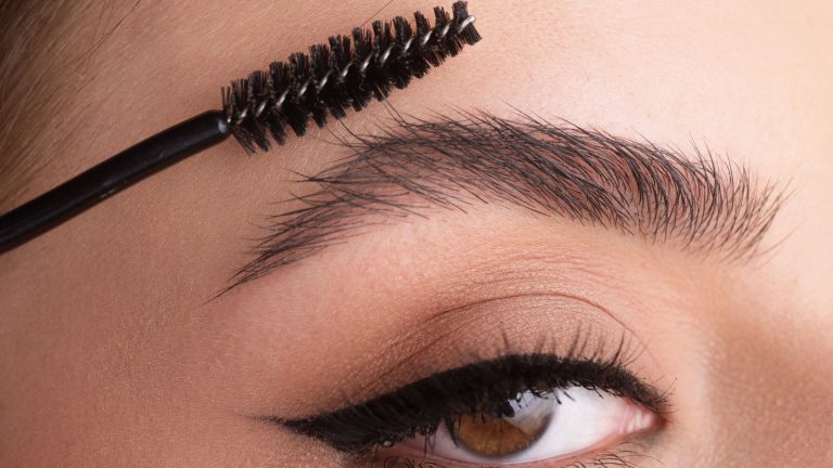Woman curling her brows, Do You Need Glue For Brow Lamination? - 1600x900