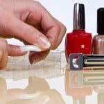 Woman applying fake nails to her fingers, What Nail Glue Do Salons Use? 8 Top Picks for Flawless Manicures - 1600x900