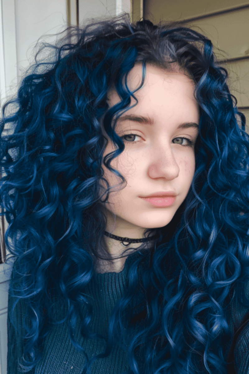 Natural curls pop with this all-over shade of dark purplish blue.