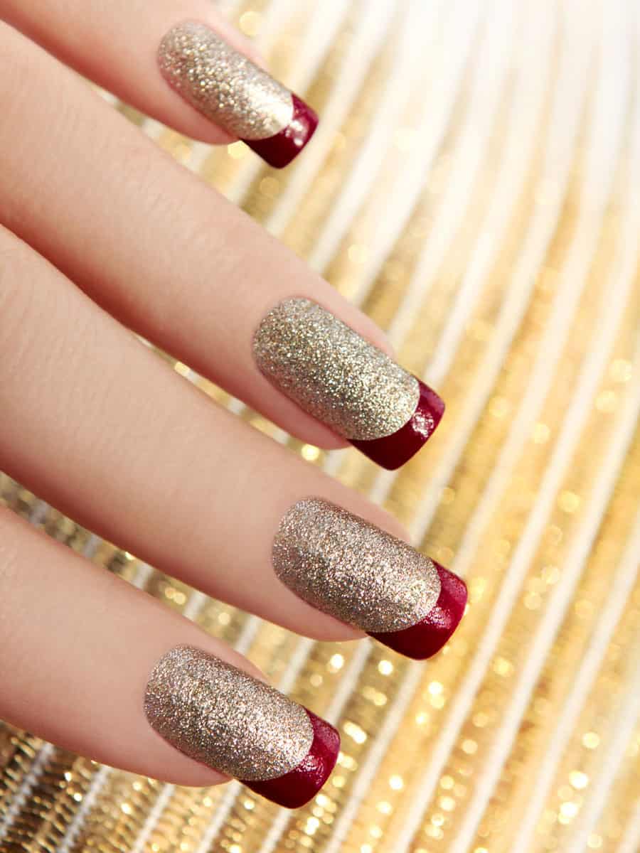 gold glitter nails with burgundy French tips