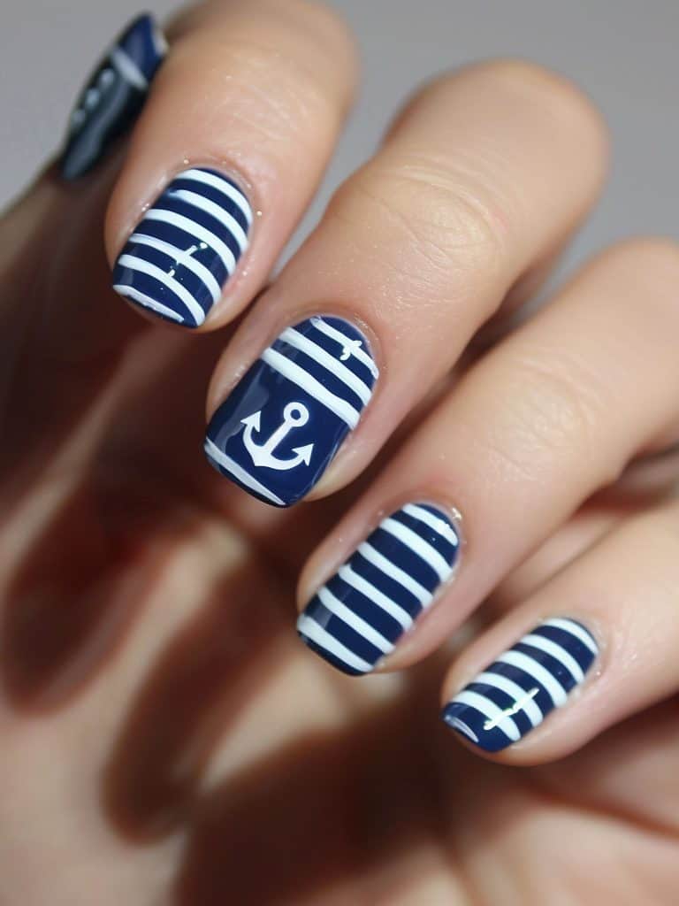 ocean-inspired nail design. nautical navy. white stripes. anchor detail