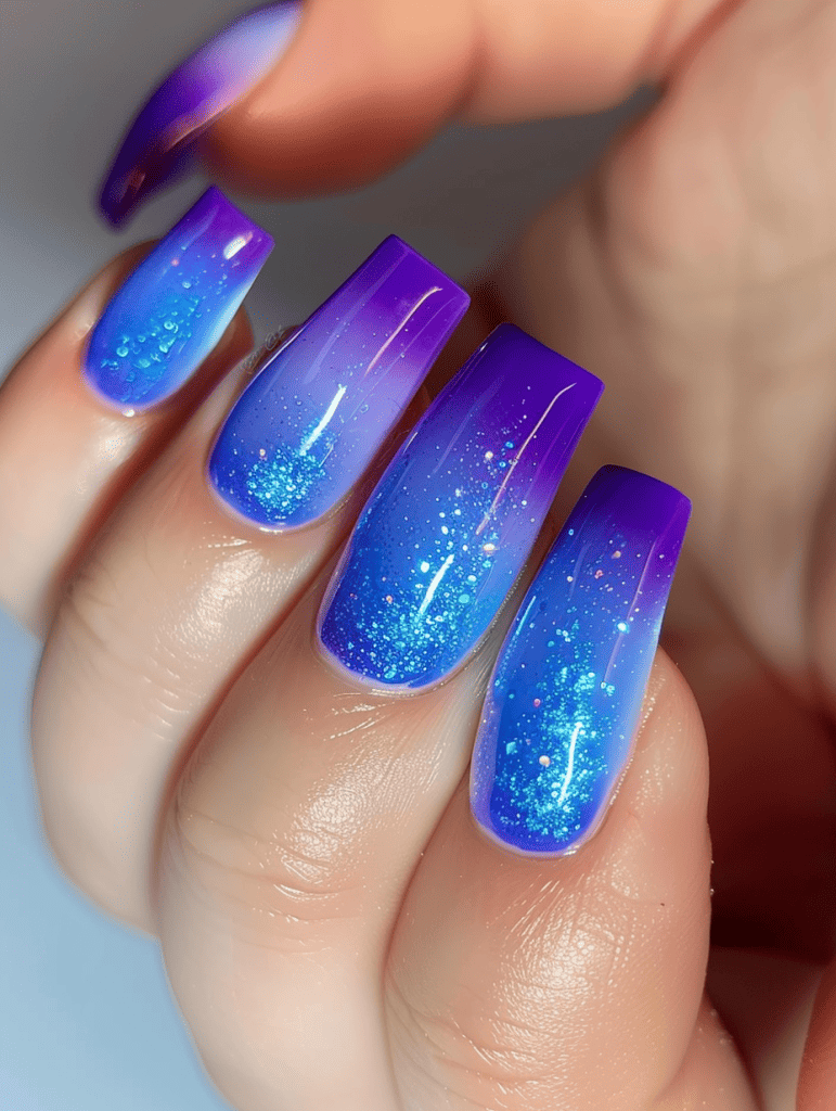 Ombre nail design. blue to purple transition with glitter accent