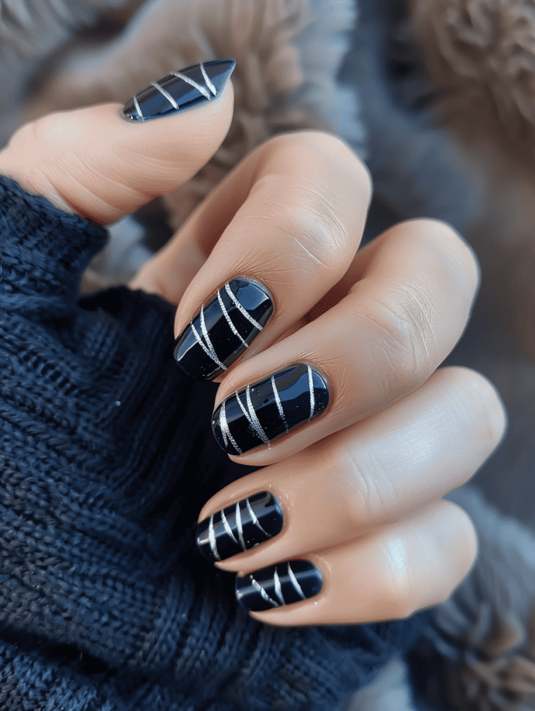 Stripe nail design with metallic silver stripes on dark blue nails